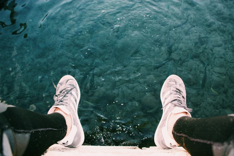 someone standing at the edge of the water next to a dock