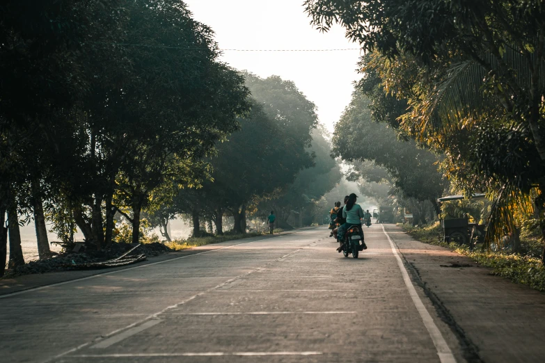 the motorcyclists travel down a dirt road in the middle of the park