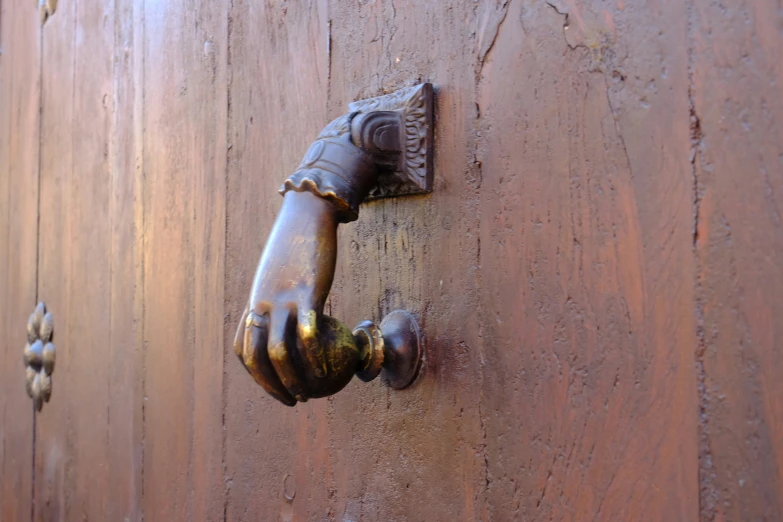 an antique door handle on the front of a wooden door