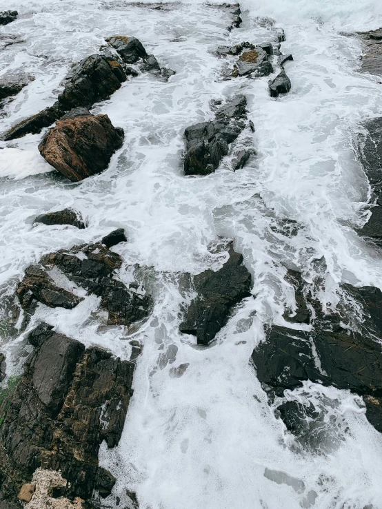 waves crash on rocks along the shore line