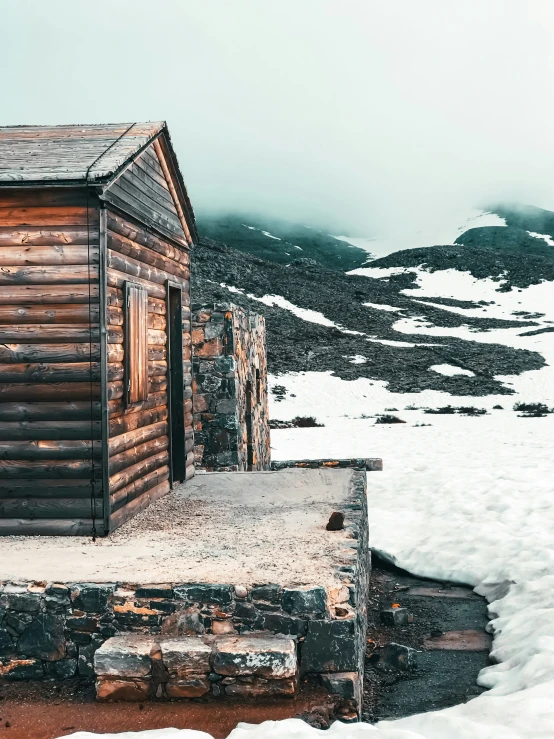 a cabin on top of a mountain with snow