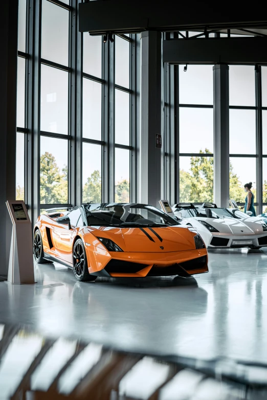 many orange cars parked in front of some big windows