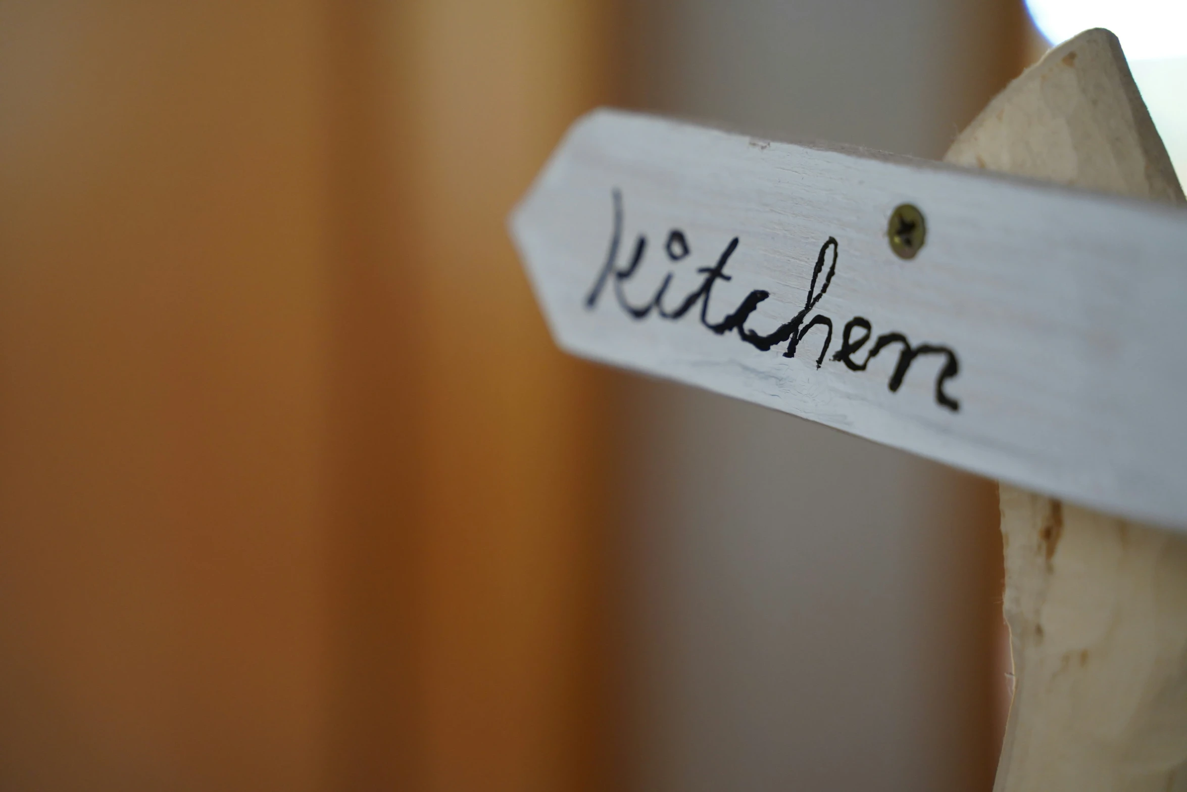 a name board with a wooden handle saying kitchen