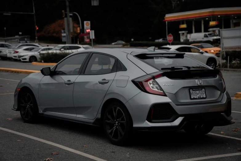 the rear end of a gray civic rs car in parking lot