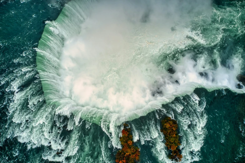 a large body of water surrounded by foamy green waves