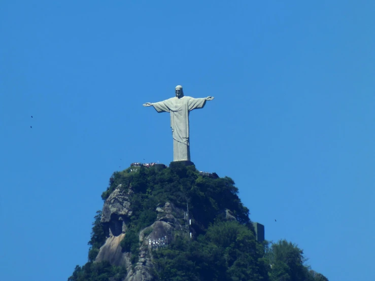 the statue of jesus is on top of a rock