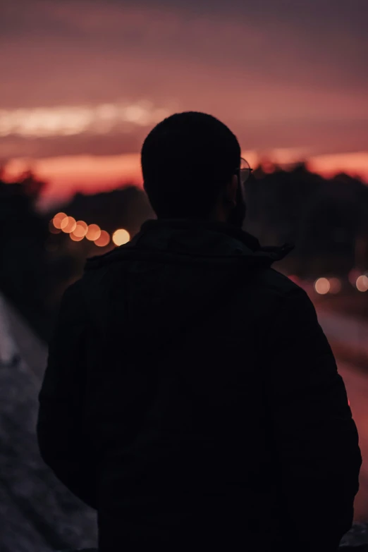 a man looking out at the city from atop a hill