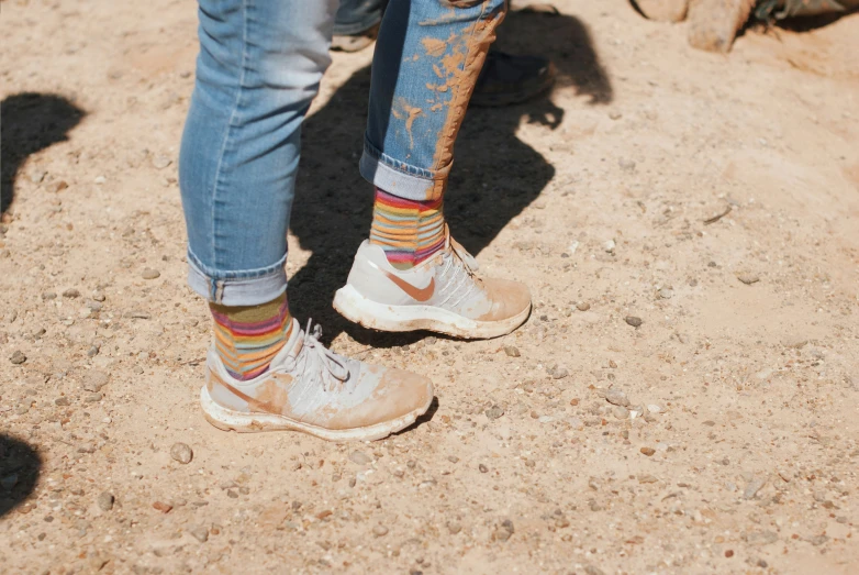 someone wearing colorful socks and socks in the dirt