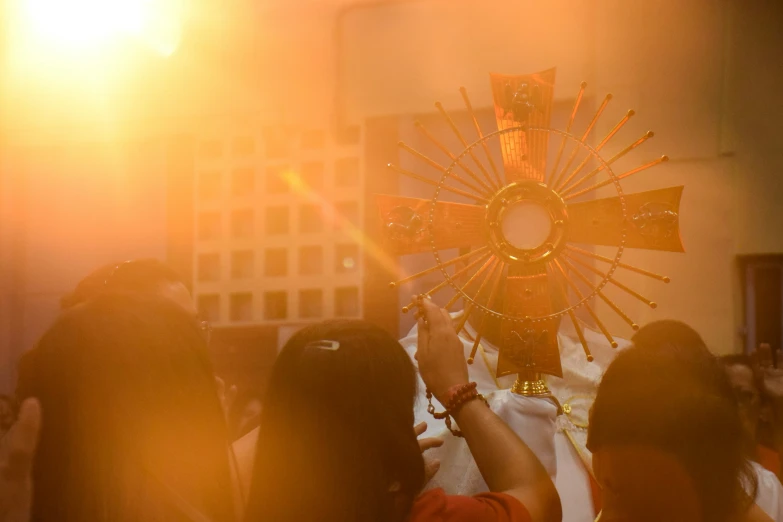 a crowd is standing around a cross and taking pictures