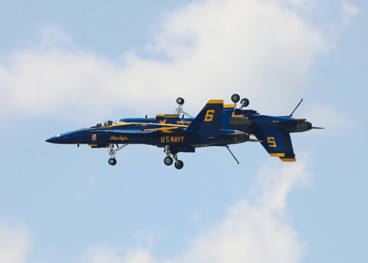 two blue fighter jets flying through the air