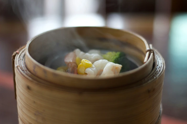 an asian food dish with vegetables in broth, and another food item