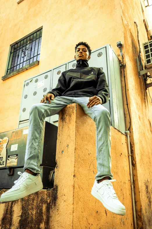 a young person sitting in front of a building