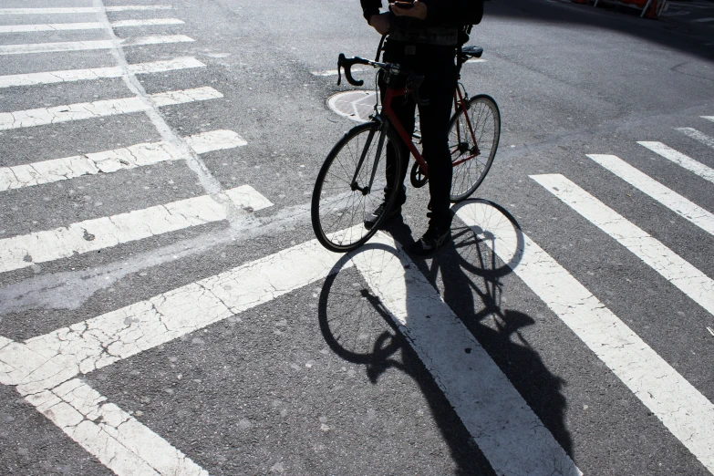 a person standing next to a bike on the side of a road