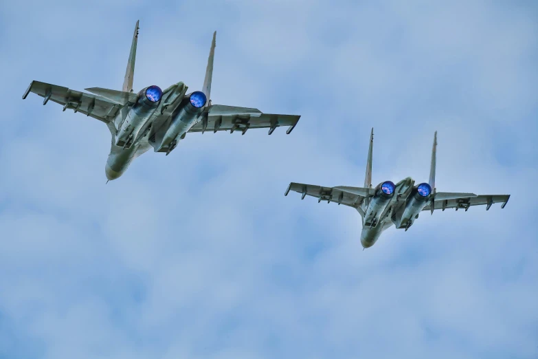 two jets flying through the sky in formation