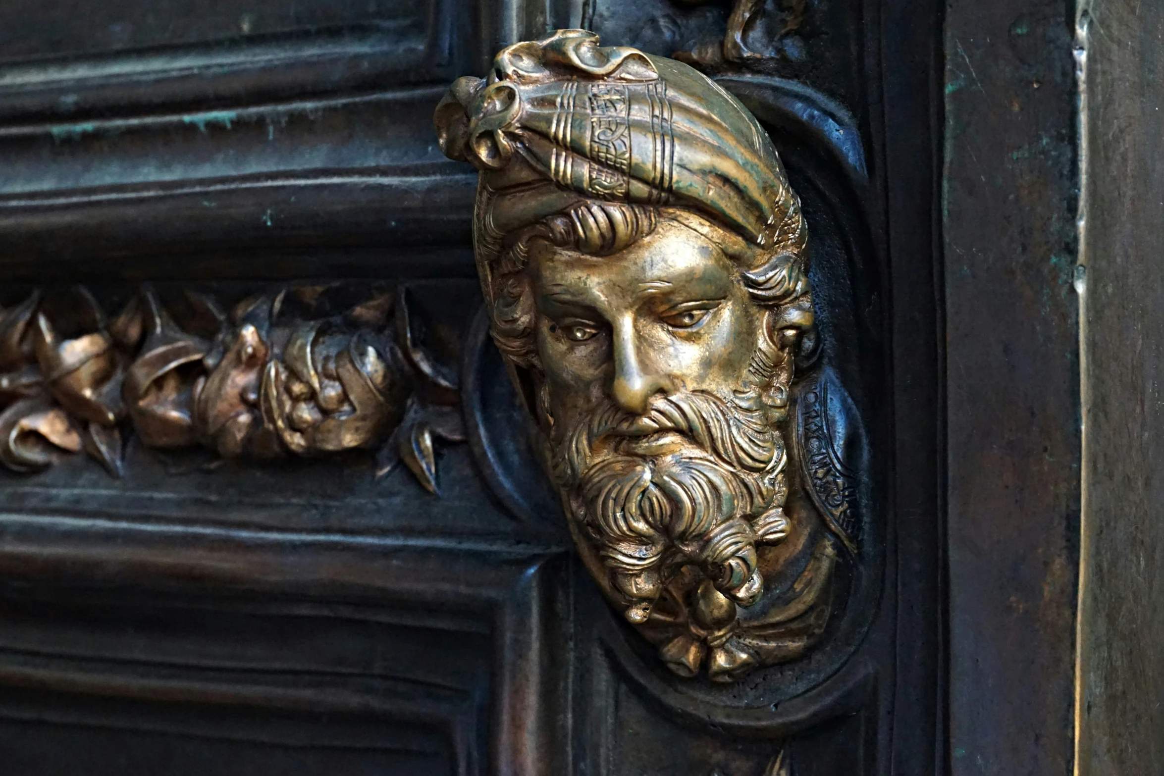 a head in an antique door with ornate carvings on the outside