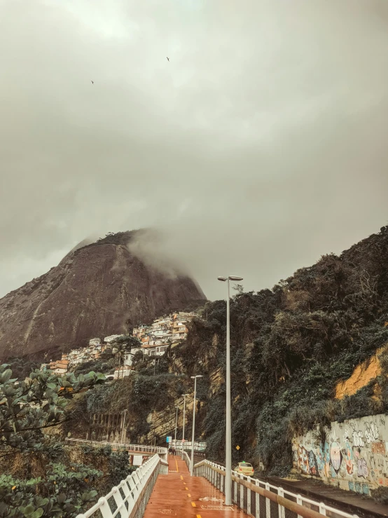 a walkway leading to a mountain that is covered with graffiti