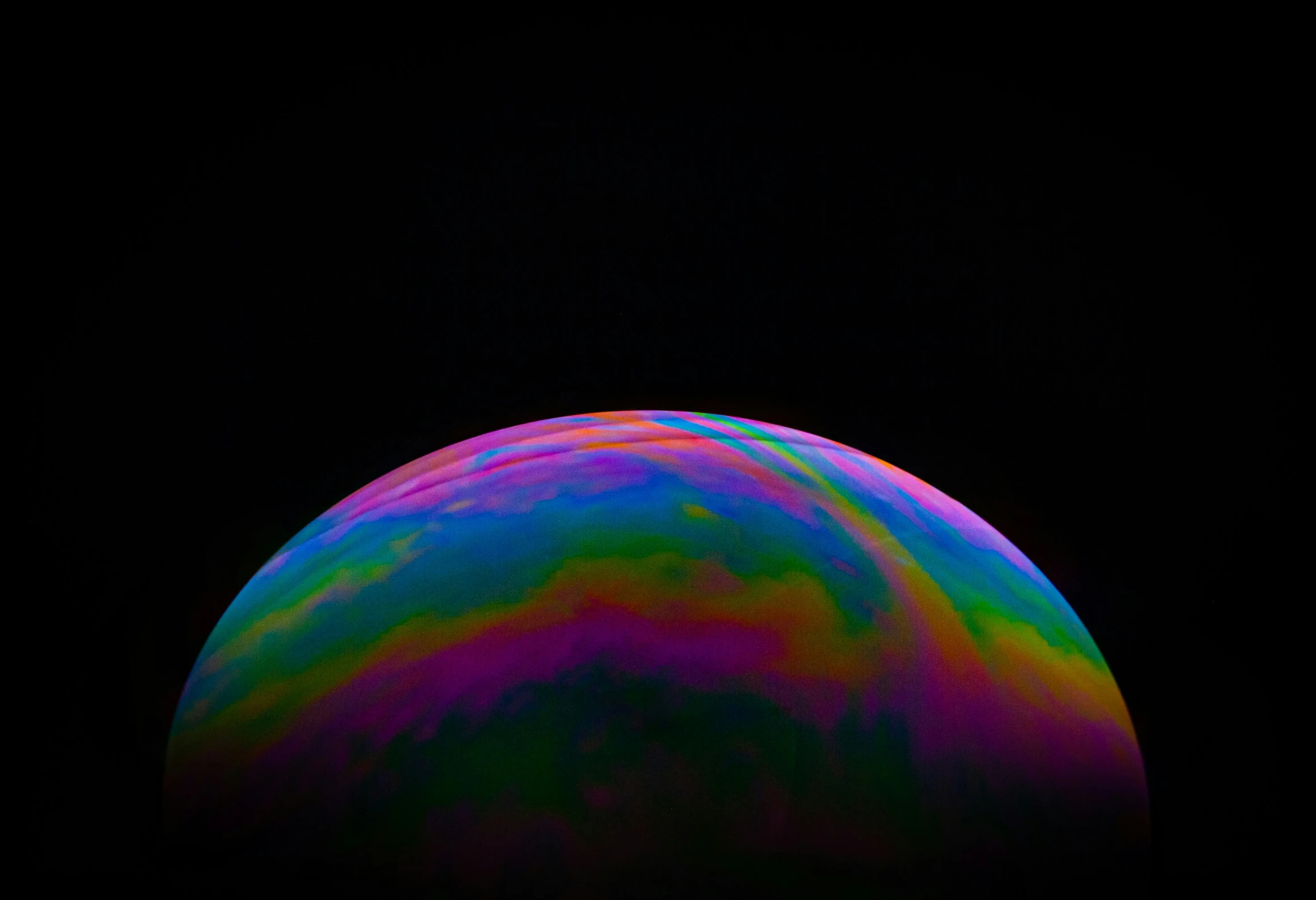 a rainbow ball with a black sky background