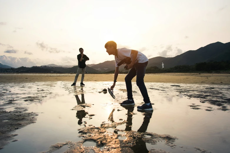 two people in the water trying to find what to put in their shoes