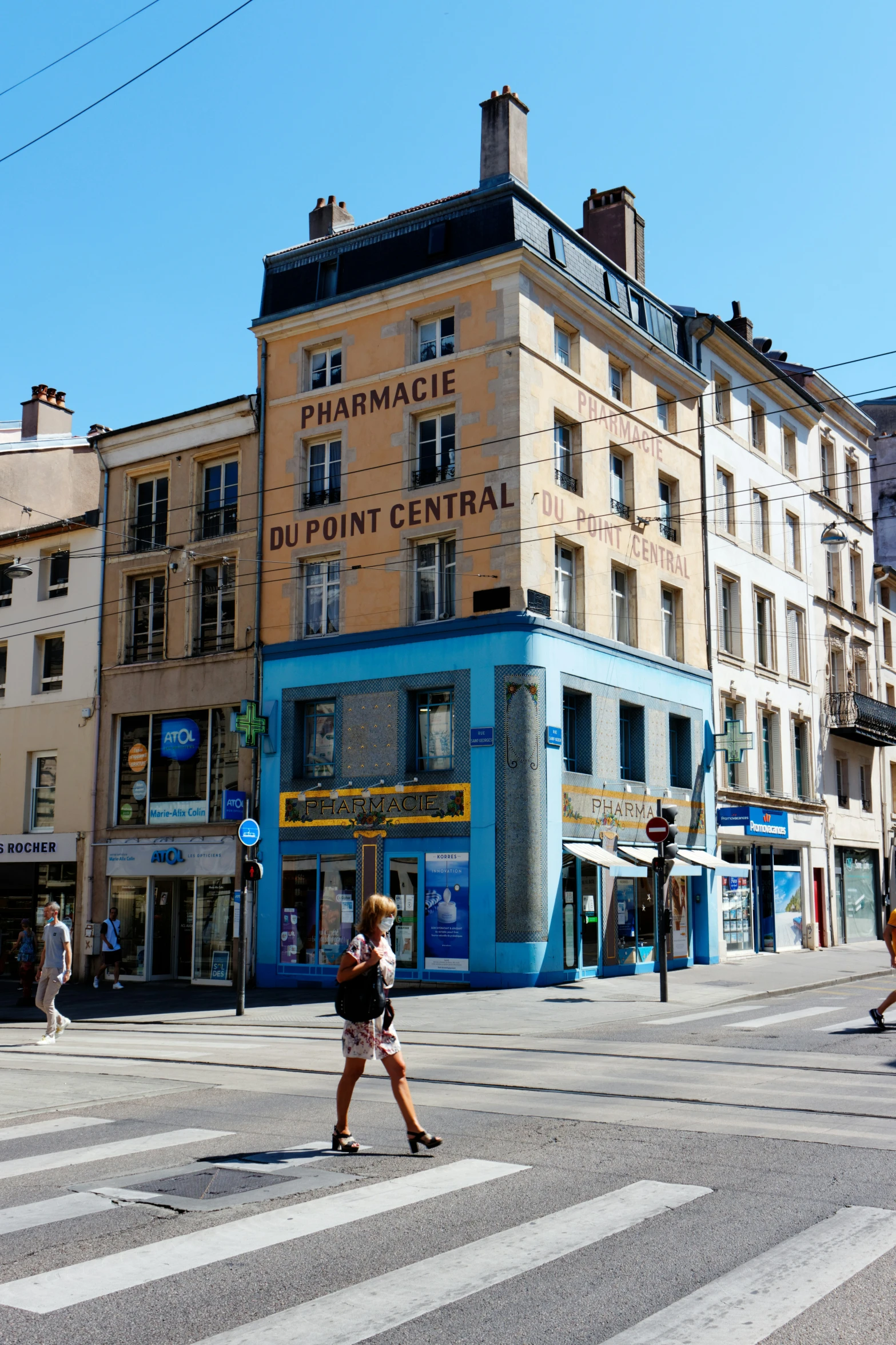 a city intersection with people walking across it