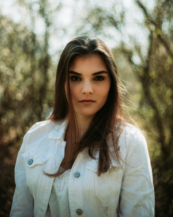 a woman wearing a white jacket posing for a po