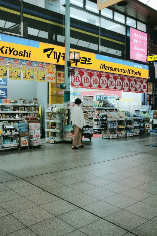 two men in white outfits are walking by goods for sale