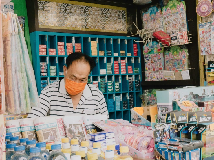 a shop keeper wearing a surgical mask and putting on his face