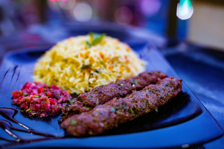 some meat and vegetables on a blue plate