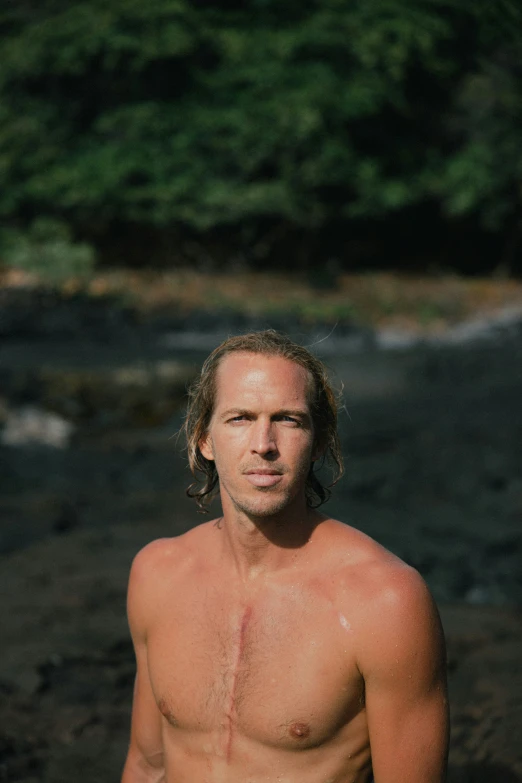 a man standing in a wet area looking at the camera