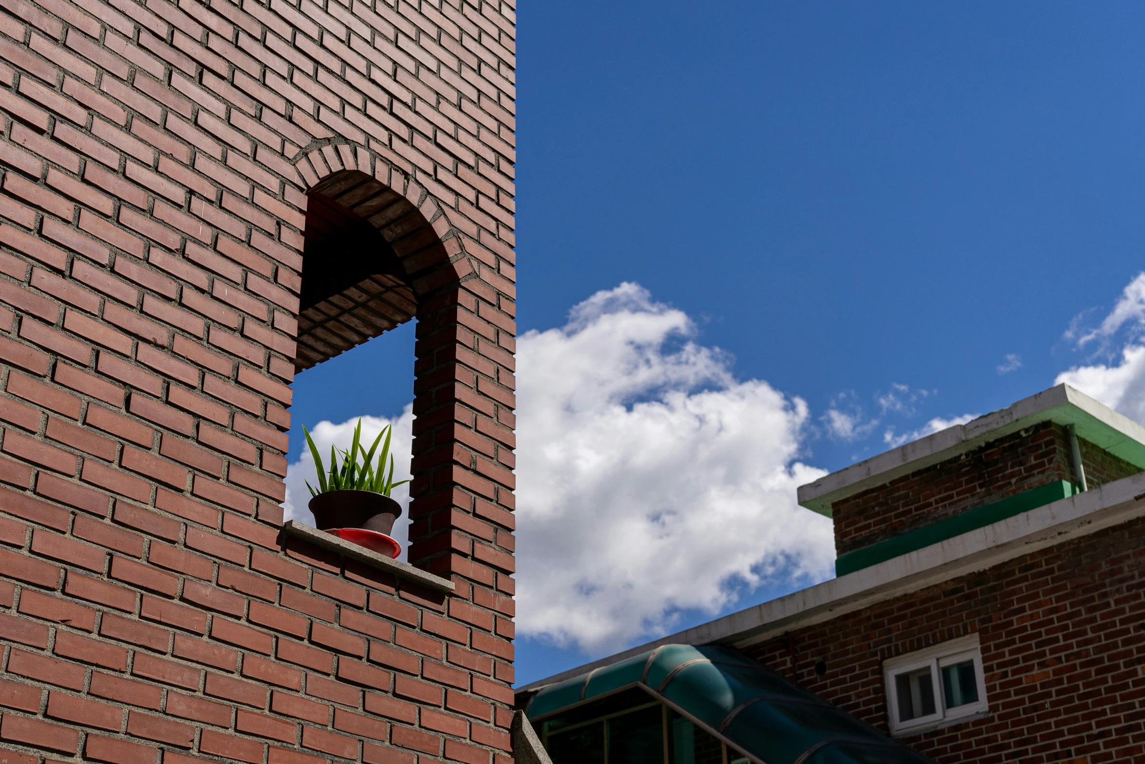 a brick building with a brick window and brick planter on one side of the window