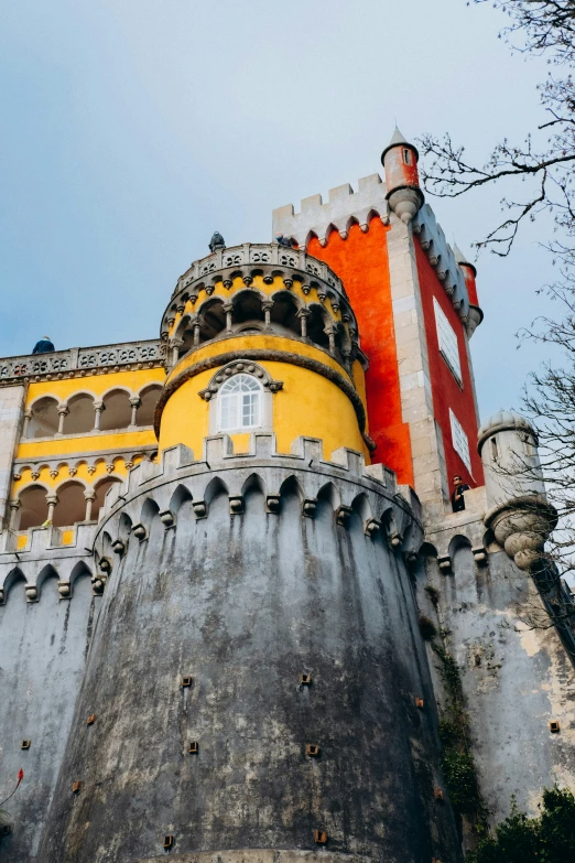 a castle building with yellow walls and a clock on the front