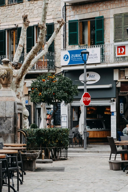 a woman is sitting on a bench outside of an old fashion business