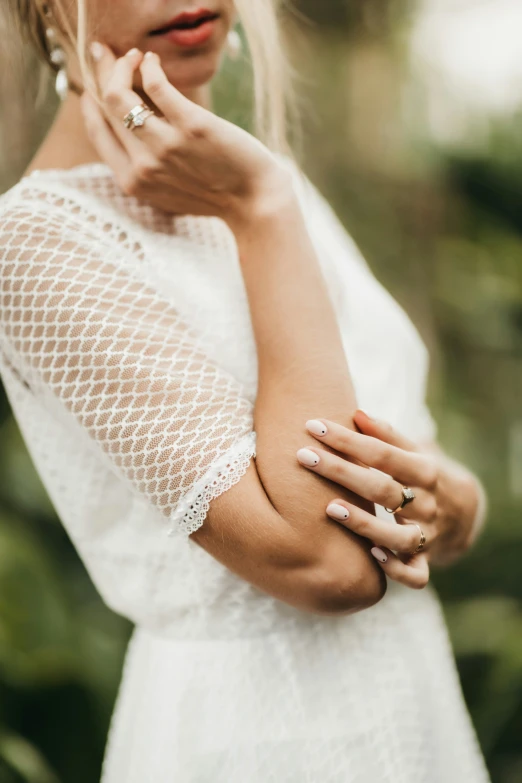 a woman is posing for a po wearing a white dress