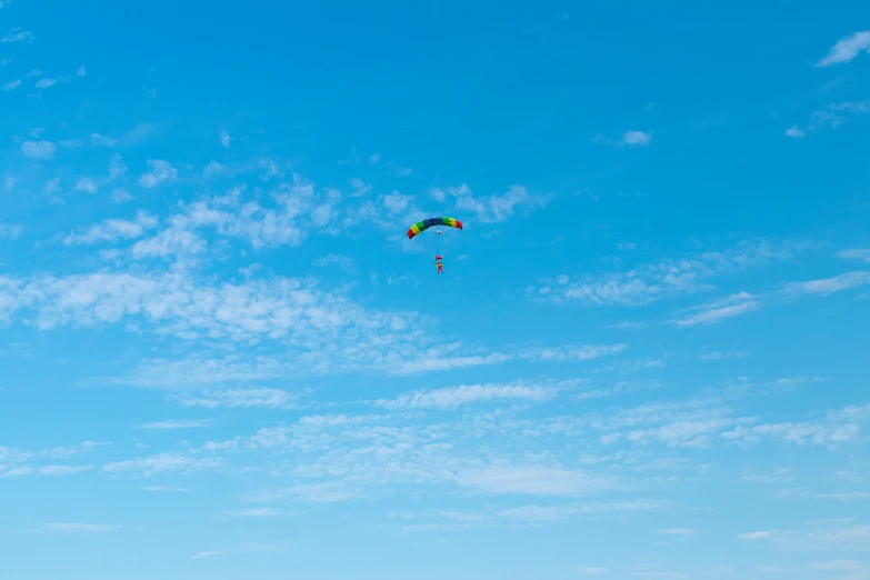 some people and kites on a beach against a blue sky