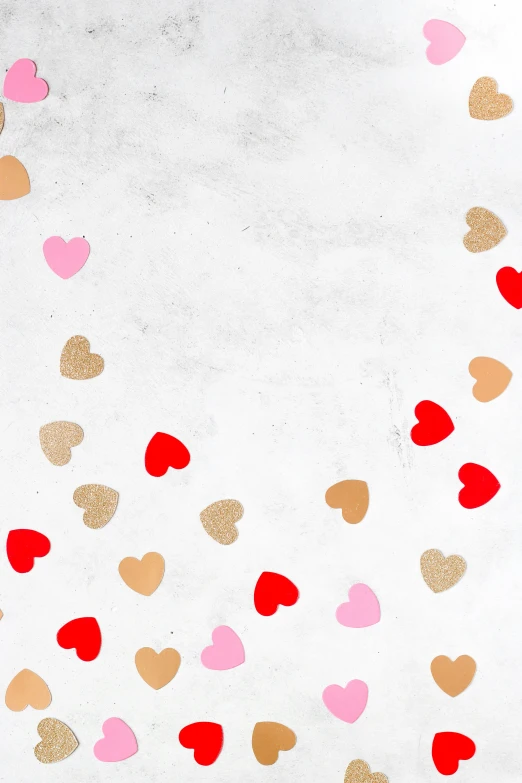 gold and red hearts on white paper against a light background