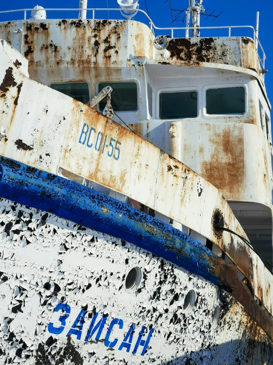 a rusted up ship is against the sky