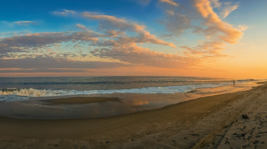 the sun rises over a sandy beach on a sunny day