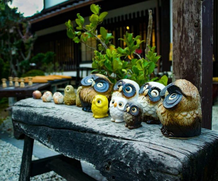 an outdoor garden features small carved and painted owls