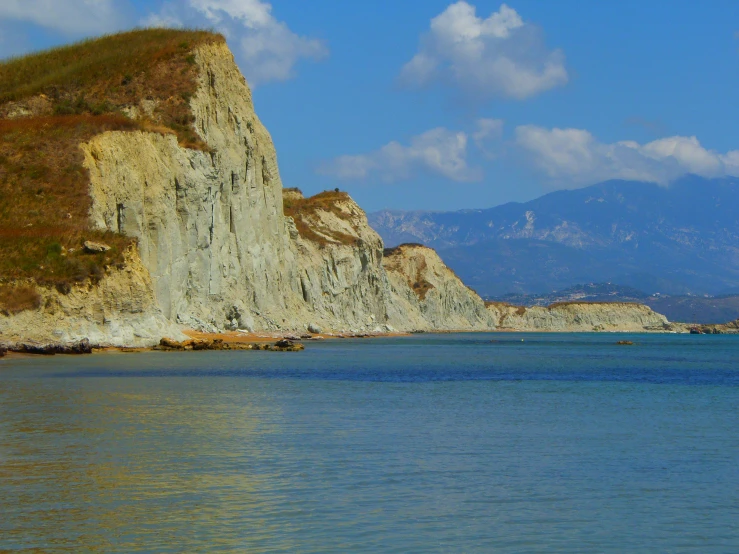 an image of some blue water and the cliff with cliffs in the background