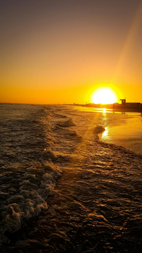 a boat on the ocean at sunset with the sun setting in the distance