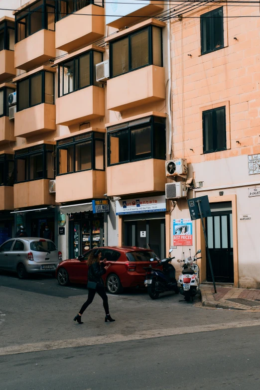 a person walking past a tall building on the street