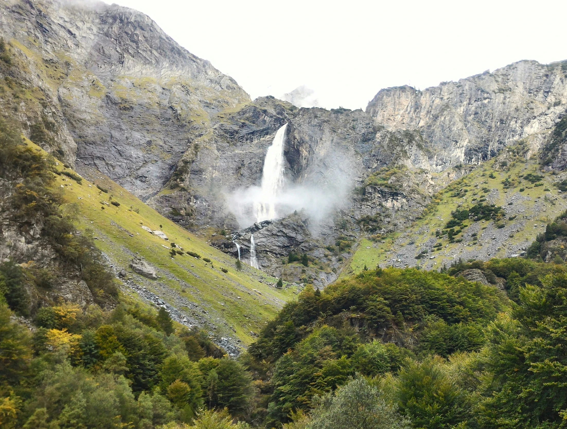 a waterfall that is sitting in the middle of some trees