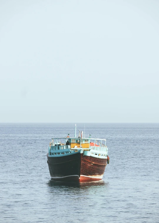 the two boats are anchored in the calm water