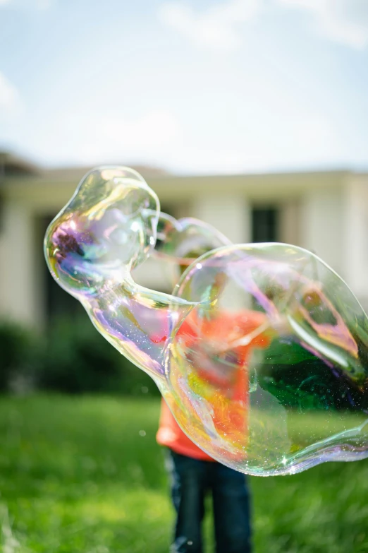 a boy is playing outside with soap bubbles