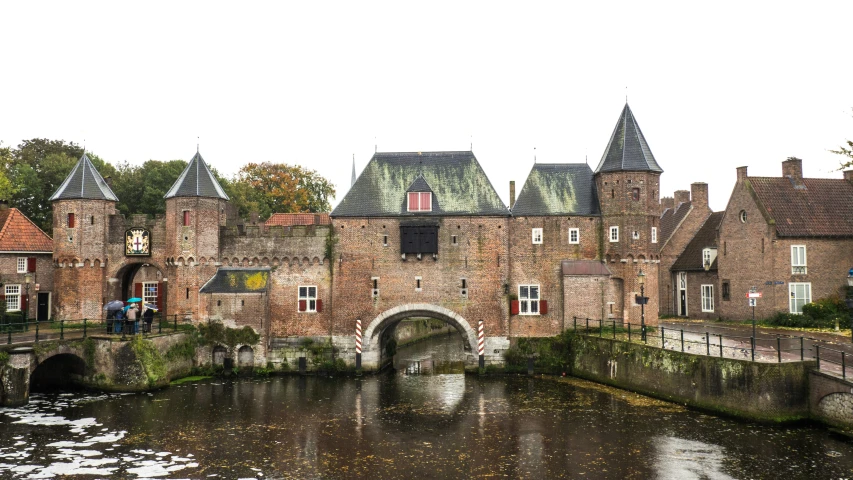 people are standing by the water near old buildings