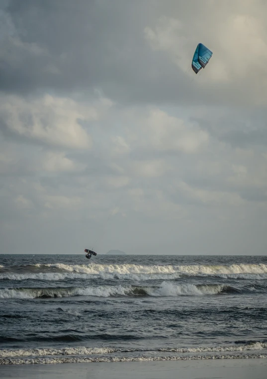 someone is kite surfing in the ocean on the beach