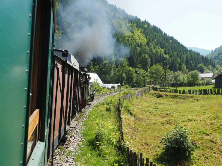 the smoke from the train is rising as it comes off the tracks