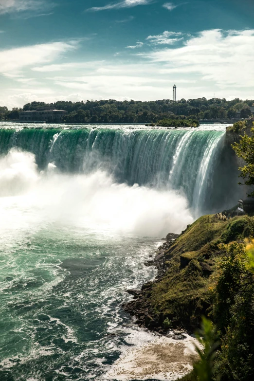 a person taking a picture of the water in front of the waterfall