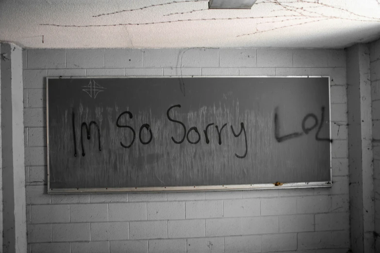 there is graffiti on a wall in an old classroom