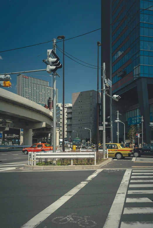 cars driving through a city street near high rises