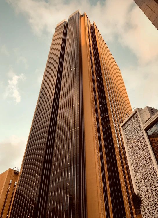 the bottom of a tall skyscr building with a blue sky in the background